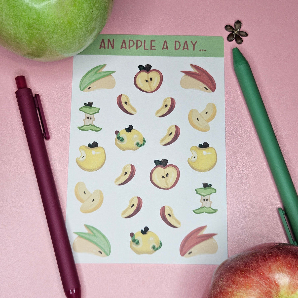 A sheet of cute apple-themed stickers with the text 'AN APPLE A DAY.