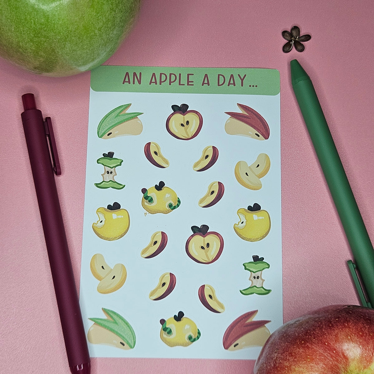 A sheet of cute apple-themed stickers with the text 'AN APPLE A DAY.