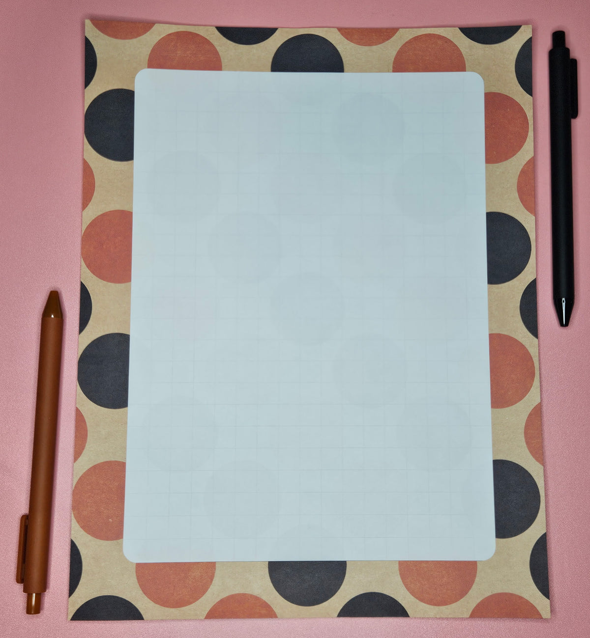 orange and black polks dotted paper with a light grid