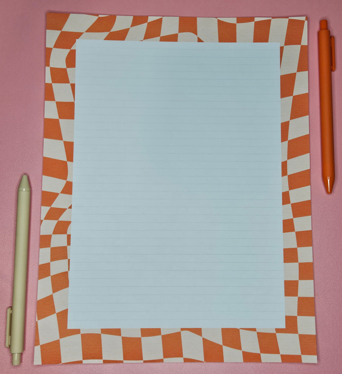 wonky orange grid patterned paper with a white block with light lines.