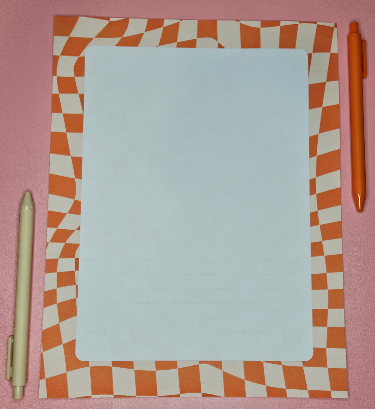 wonky orange grid-patterned paper with a white block with light gridlines.